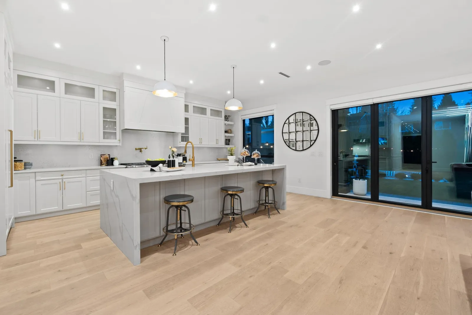 Chef’s kitchen with marble-look waterfall island and pendant lighting in the Crescent Beach custom home at 12686 25 Avenue, South Surrey BC